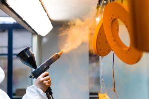 Quy trình phun bột giúp minh họa rõ sơn tĩnh điện là gì trong sản xuất công nghiệp 